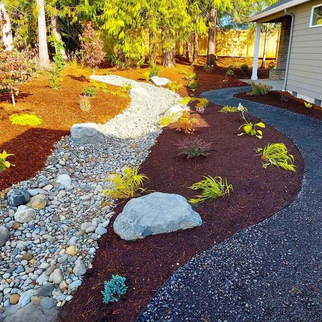 River Rocks Through Green Garden Beds
