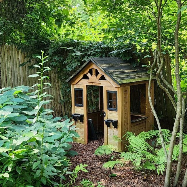 Wooden Playhouse Among Green Plants