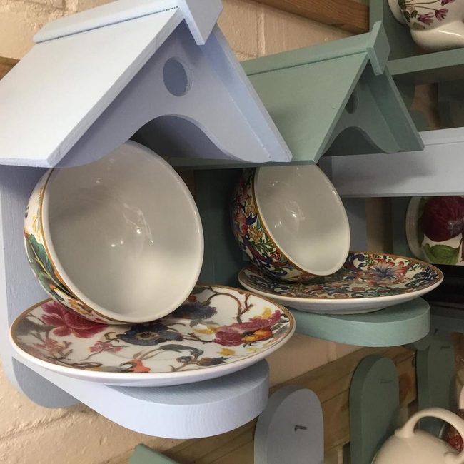 Teacups Feeding Birds Below Tiny Roofs