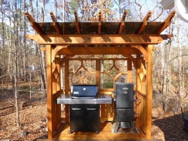 Black Metal Grill Under Wood Pergola