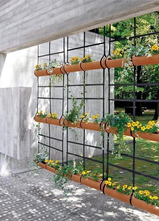Yellow Flowers In Stacked Terracotta Pipes