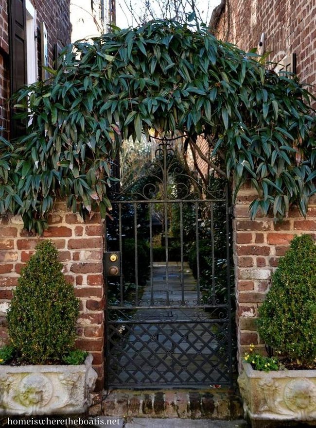 Black Iron Gate Through Weathered Brick