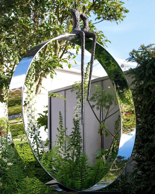 Reflective Figures On Gleaming Hoop