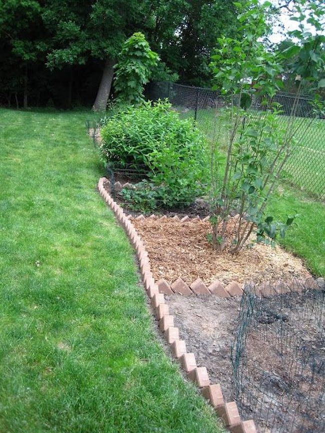 Brick-Bordered Garden Beds With Dark Mulch