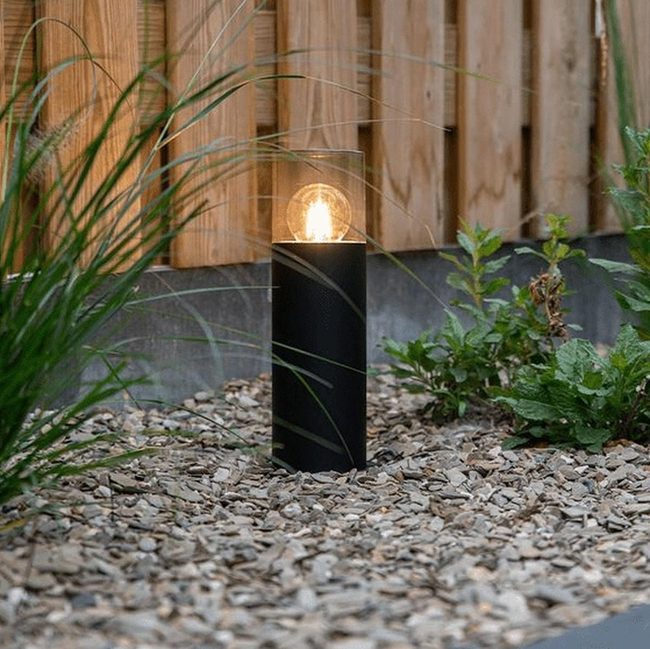 Black Lamps, Stone, And Leafy Garden