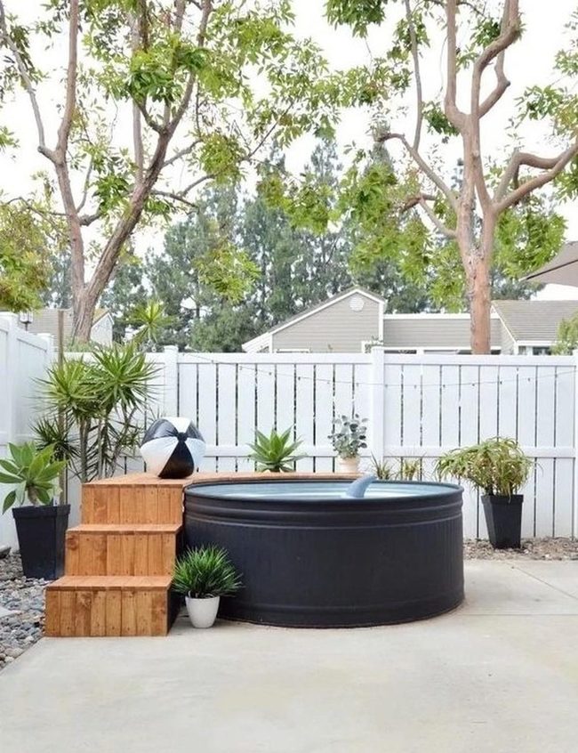 Black Soaking Tub Under Leafy Shade