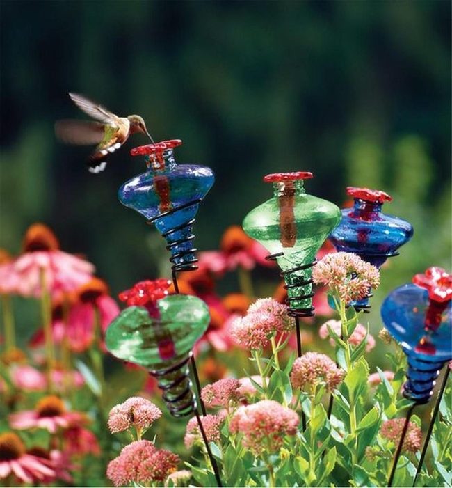 Colorful Glass Stakes Among Pink Flowers