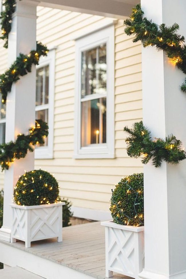 Yellow Porch With Evergreen Garland Lights