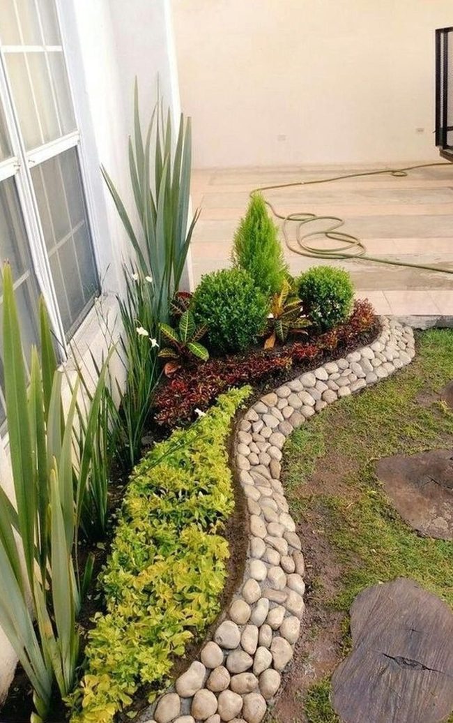 Stone-Bordered Garden With Layered Green Plants