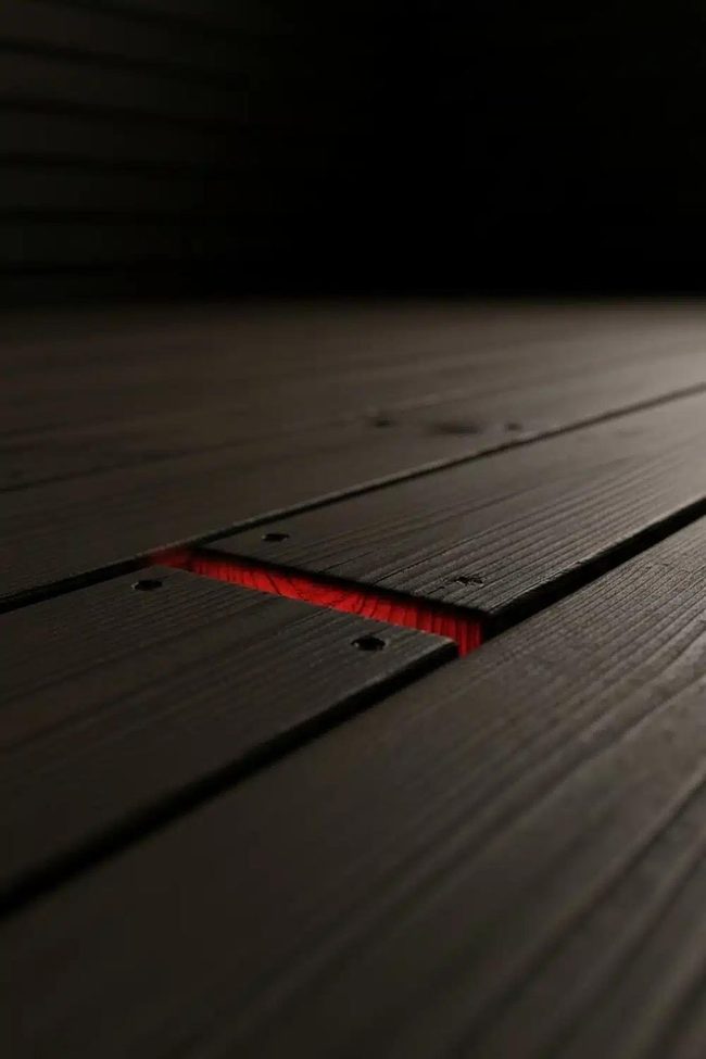 Red Pulsing Pendant Light Beneath Black Deck